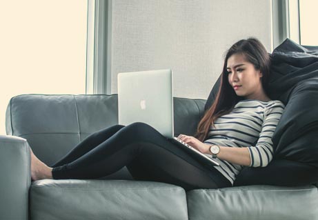 woman sitting on couch with laptop